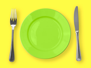 Knife, green plate and fork on yellow background