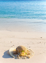 Straw  hat lay on sand at edge of sea