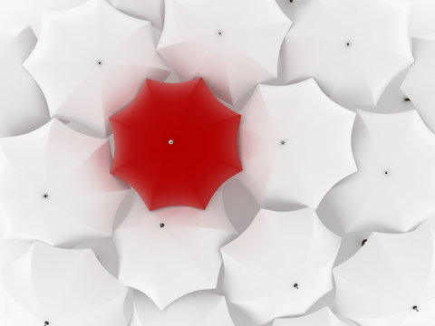 One unique red umbrella, among other white
