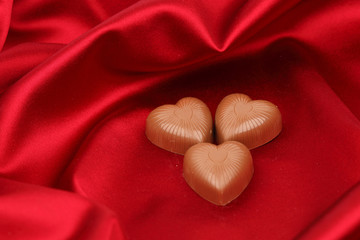 Fototapeta premium candy hearts on red satin