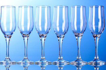 Few empty wine glasses on blue background