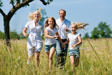 Familie läuft in der Wiese