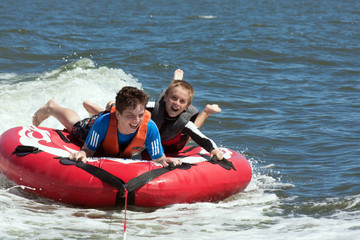 Two Boys Have Fun on Inflatable in River