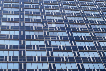 View of modern glass and metal blue building with many windows