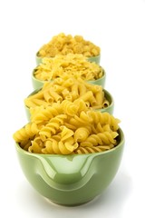 Assorted raw pasta noodles in green ceramic dish