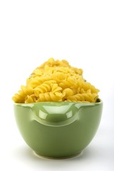 Assorted raw pasta noodles in green ceramic dish