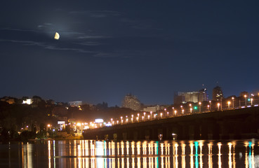 Moonset in Kiev over Dnieper river in lights