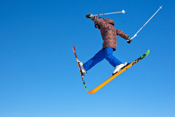 flight of young skier on blu sky background