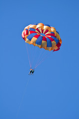 Parasailing under blue sky.