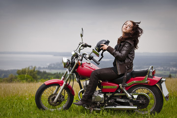 Fototapeta na wymiar Frau setzt Motorradhelm ab und schüttelt Haare