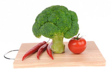 broccoli and tomato and red pepper on cutting board