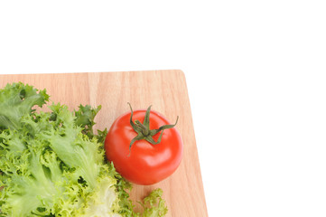 green salad and tomato on cutting board isolated on white