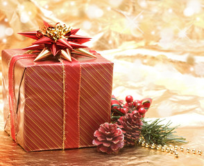 Fototapeta na wymiar Red Christmas gift box on background of defocused golden lights.