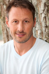 Fototapeta premium Portrait of handsome man sitting in park