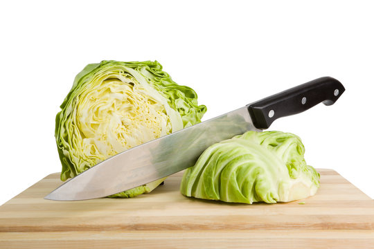 Fresh green iceberg lettuce with knife on wooden chopping board