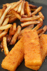 Fischstäbchen mit Pommes frites auf einer Pfanne