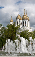 Fototapeta na wymiar fountain near church with cloudy sky