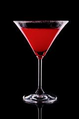 Martini glass with red coctail on black background