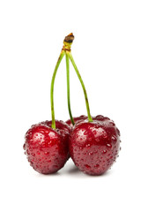 Three sweet cherries with drops over white