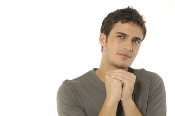 Young man thinking and looking away, holding his hand at chin