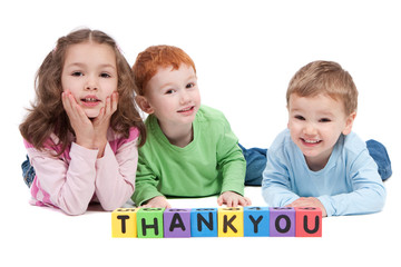 Three happy children with thankyou kids letter blocks