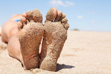 bottom of male feet covered with sand - obrazy, fototapety, plakaty