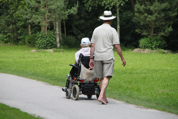 Altes Paar mit Rollstuhl im Park