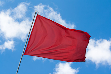 Rote Flagge vor blauem Himmel