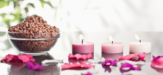 Obraz na płótnie Canvas Pink petals with lighted candles and a bowl of brown gravel