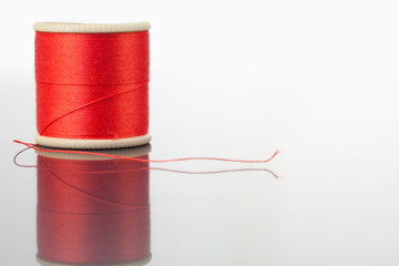 Red spool of thread on a table