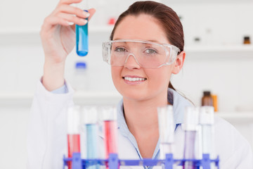 Young scientist storing a test tube looking at the camera