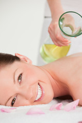Obraz na płótnie Canvas Portrait on a smiling woman having massage oil versed on her bac