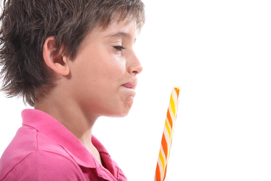 Young boy licking his lips at the sight of his lollypop