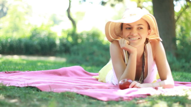 Young beautiful woman relaxing in the park, dolly shot
