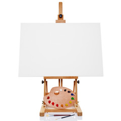 Easel with blank canvas palette paint and brushes isolated on wh