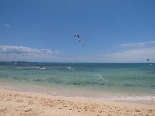 Strand mit Kitesurfer im Hintergrund