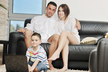 Fototapeta premium happy young family have fun and working on laptop at home
