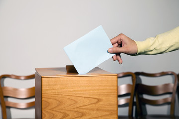 Frau bei Wahl mit Stimmzettel und Wahlurne