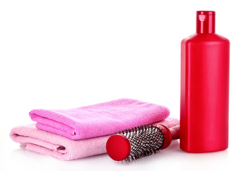 Shampoo bottles and hair brush on white
