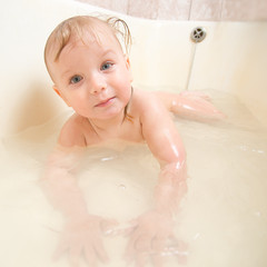 Adorable baby taking bath and swim on chest