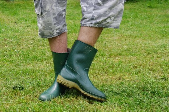 Mężczyzna w kaloszach na trawie
