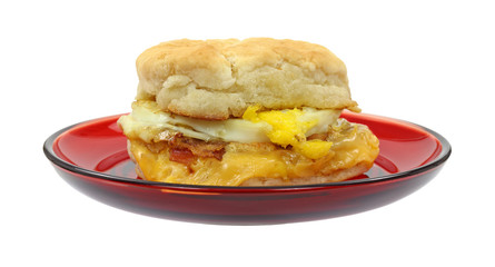 Bacon breakfast sandwich on red plate