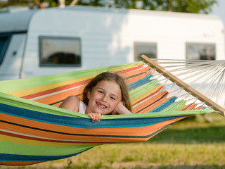 Summer camping - cute girl in colorful hammock