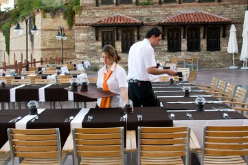 Foto op Canvas Waitress and waiter preparing restaurant. © uwimages
