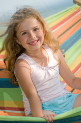 Fototapeta na wymiar Cute girl in colorful hammock
