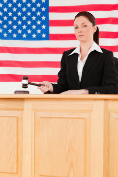 Portrait of a focused judge knocking a gavel looking at the came