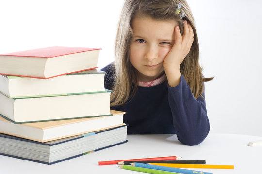 sechsj&auml;hriges M&auml;dchen sitzt lustlos neben B&uuml;chern (mr)