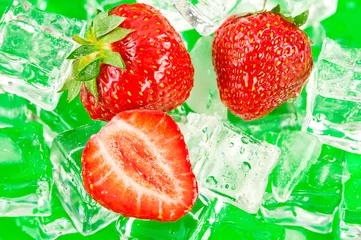 Foto op Plexiglas anti-reflex Verse rijpe aardbeien met ijsblokjes op groen oppervlak © PerfectLazybones