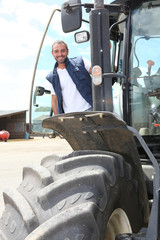 Farmer standing by the cab of his large tractor
