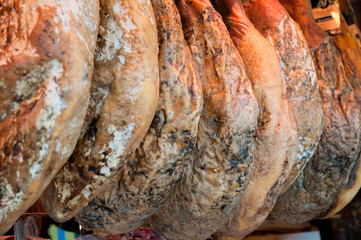Row of ham hanging in a market place